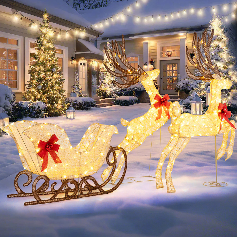 Lighted reindeer and sleigh set with 280 warm white LEDs, perfect for outdoor Christmas decoration in snowy settings.