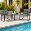 Two gray rocking chairs with thick cushions and a glass-top table create a relaxing outdoor seating area by the pool.