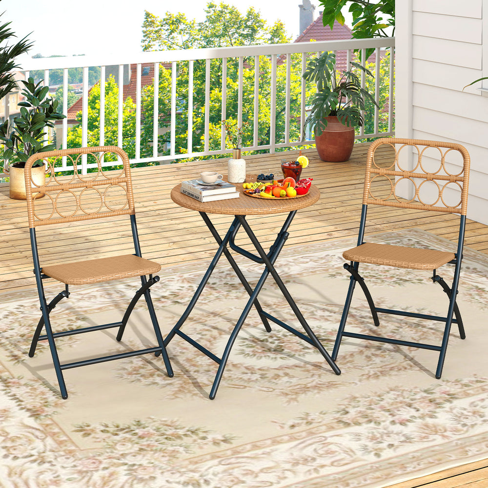 Folding round table and two chairs with handwoven rattan seats, perfect for outdoor patio dining and relaxation.