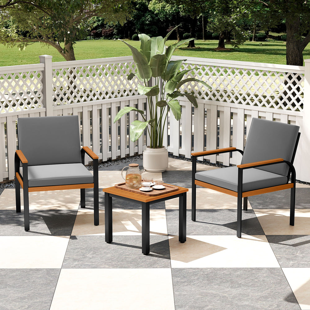 Two grey patio chairs with acacia wood armrests and a coffee table, perfect for outdoor conversation on a patio.