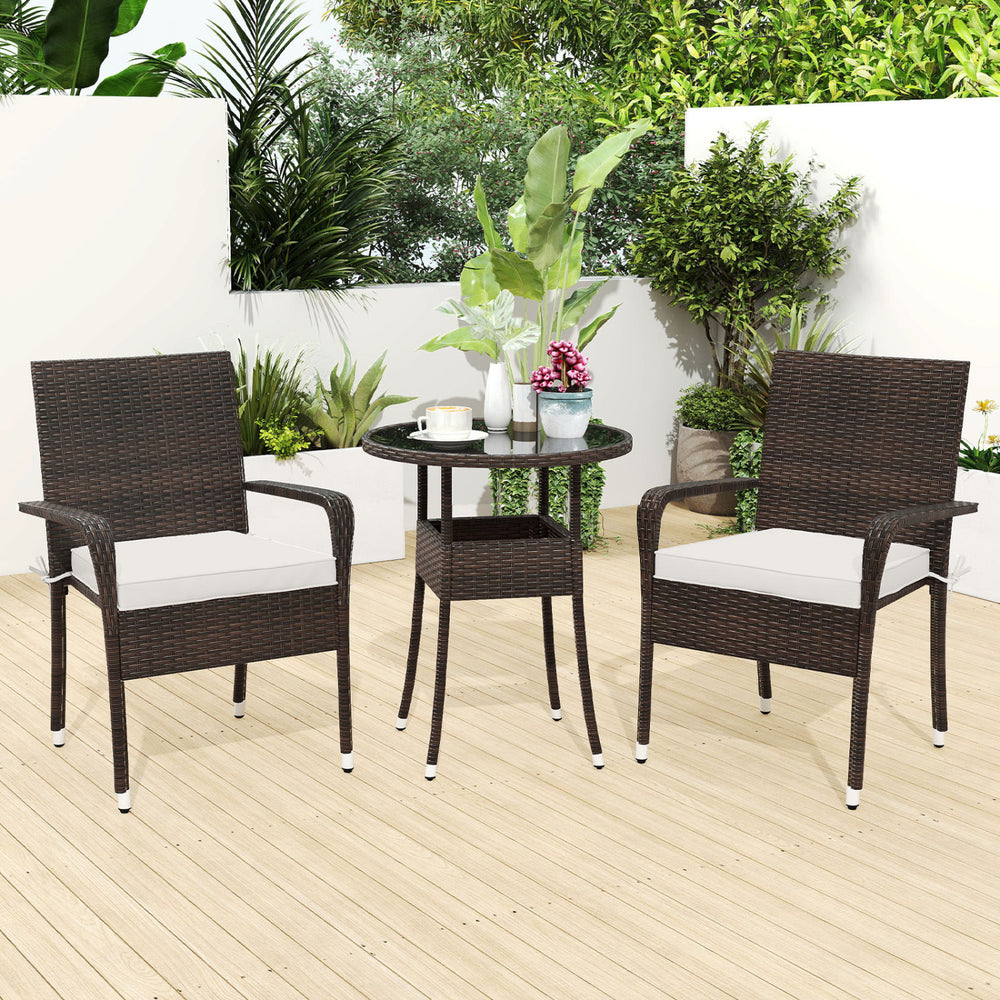 Two PE rattan wicker chairs with white cushions and a round tempered glass table, ideal for cozy outdoor gatherings.