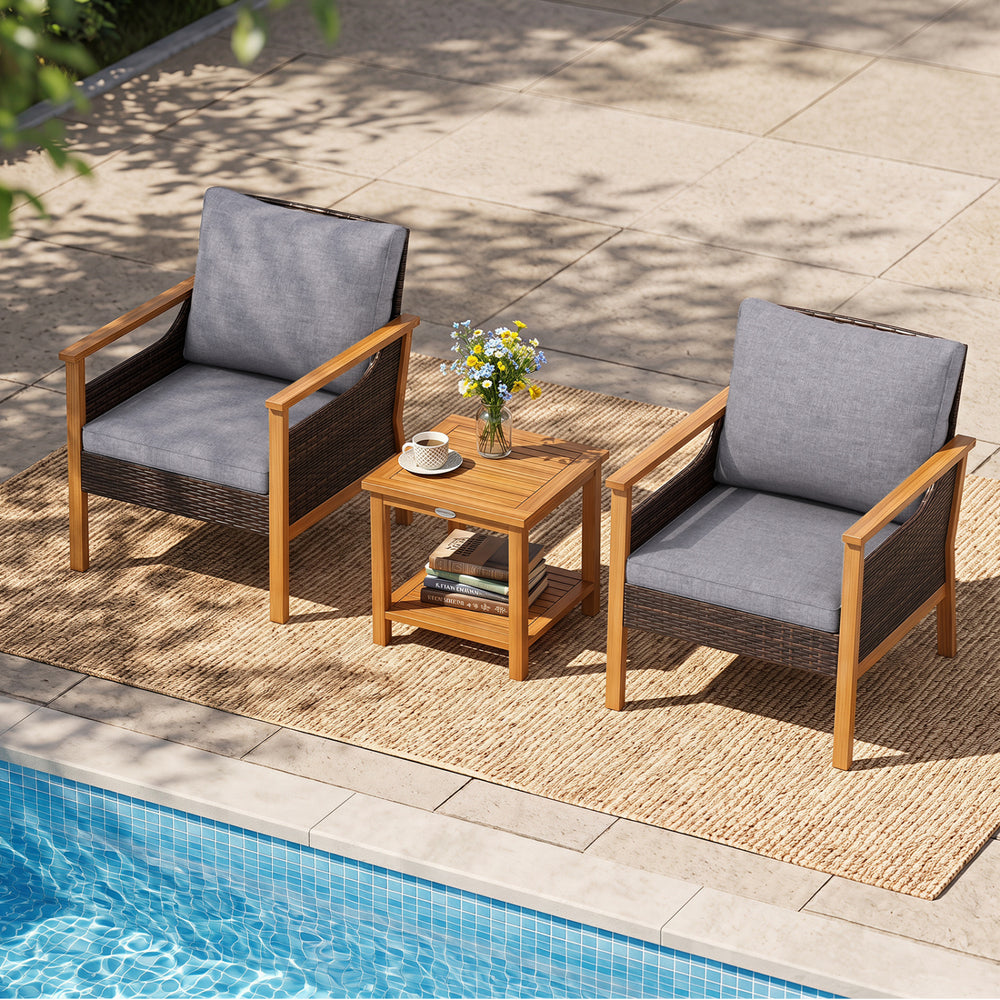 Two gray padded chairs with a slatted acacia wood side table, perfect for relaxing by the poolside or garden.