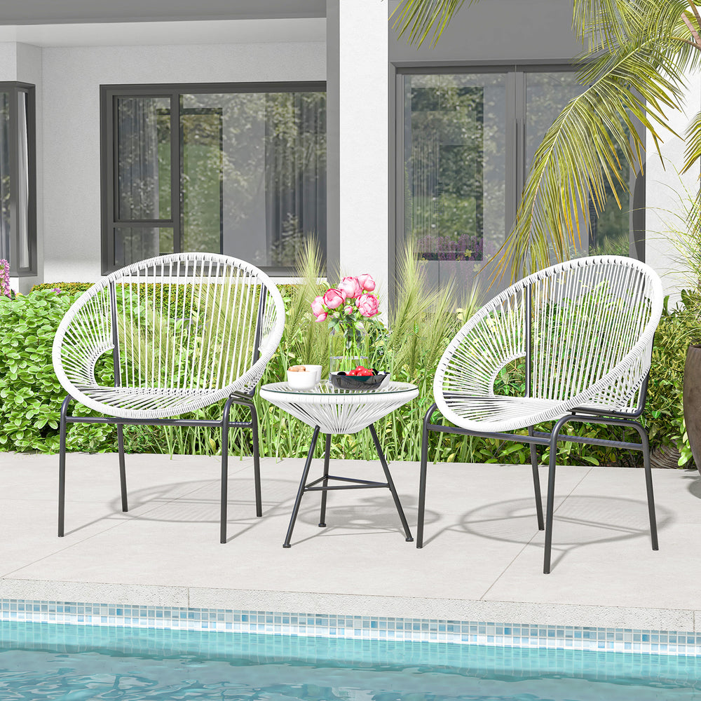 Two white Acapulco chairs and a glass table in a patio setting, perfect for outdoor relaxation and gatherings.