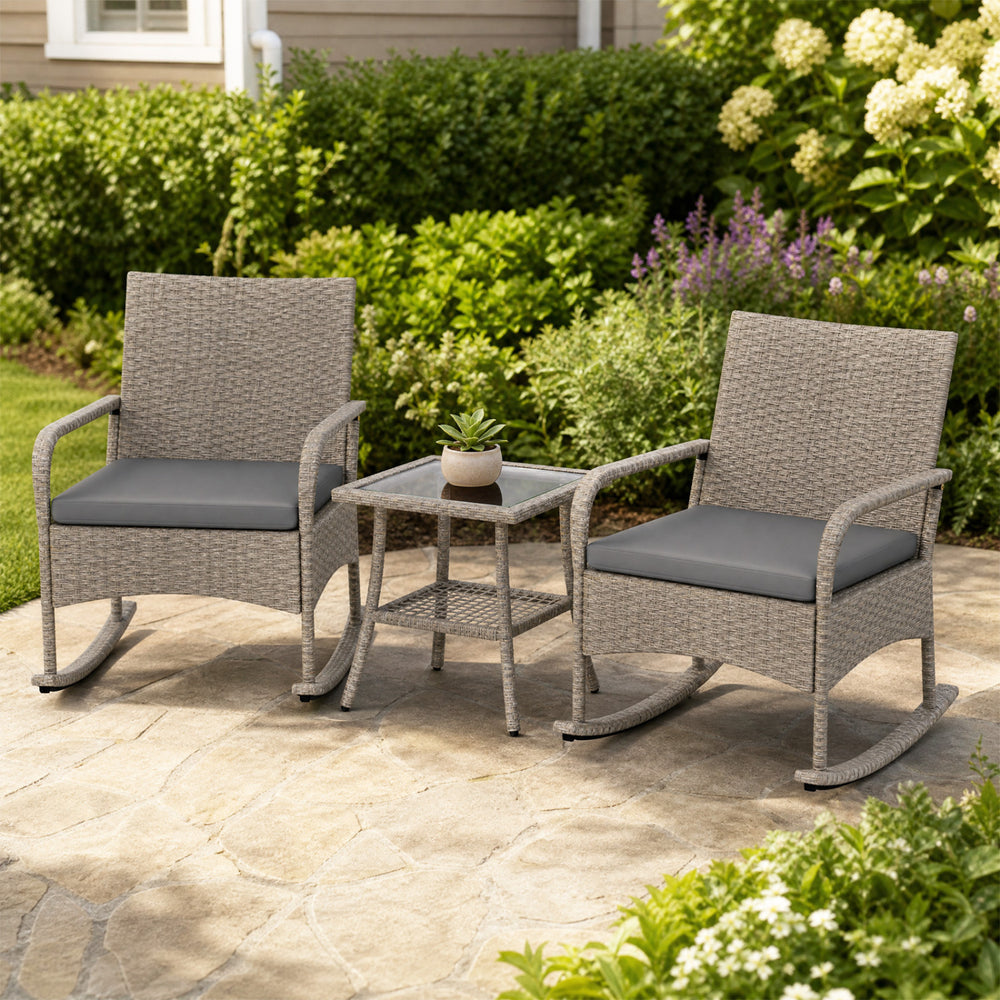 Two gray wicker rocking chairs with cushions and a glass-top coffee table, perfect for garden or patio relaxation.