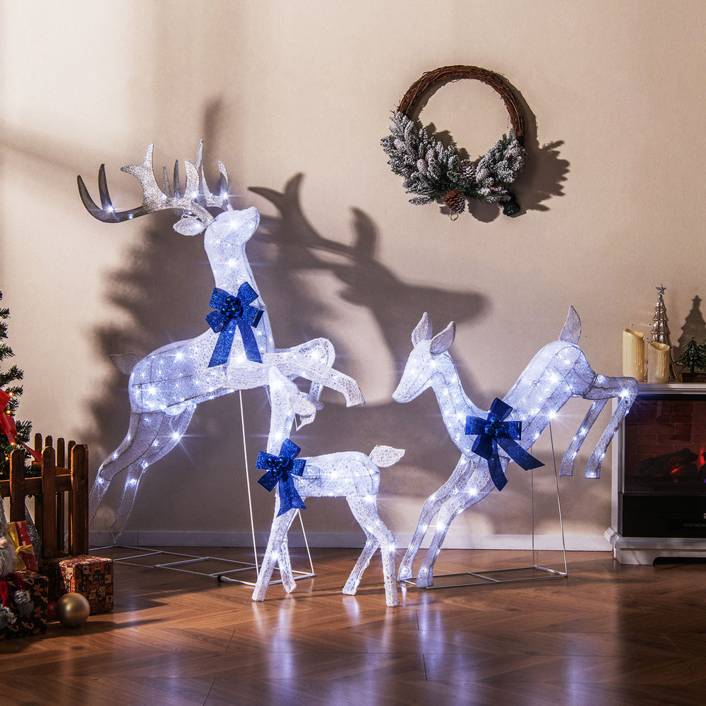 Lighted Christmas reindeer family set with 255 white lights and red bows, perfect for indoor and outdoor festive decor.