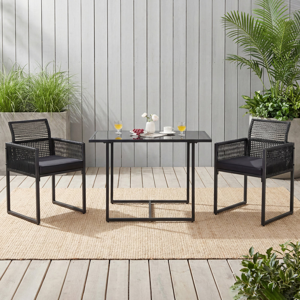 Outdoor dining set featuring two chairs with cushions and a glass table, ideal for backyard or poolside use.