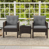 Two gray cushioned chairs with a square glass-top table in a patio setting, made of hand-woven PE rattan.