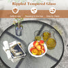 Round table with rippled tempered glass top, perfect for outdoor patios, featuring durable folding chairs for.