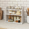 Three-tier white wooden countertop bookshelf with raised guardrails, ideal for organizing kitchen items and books.