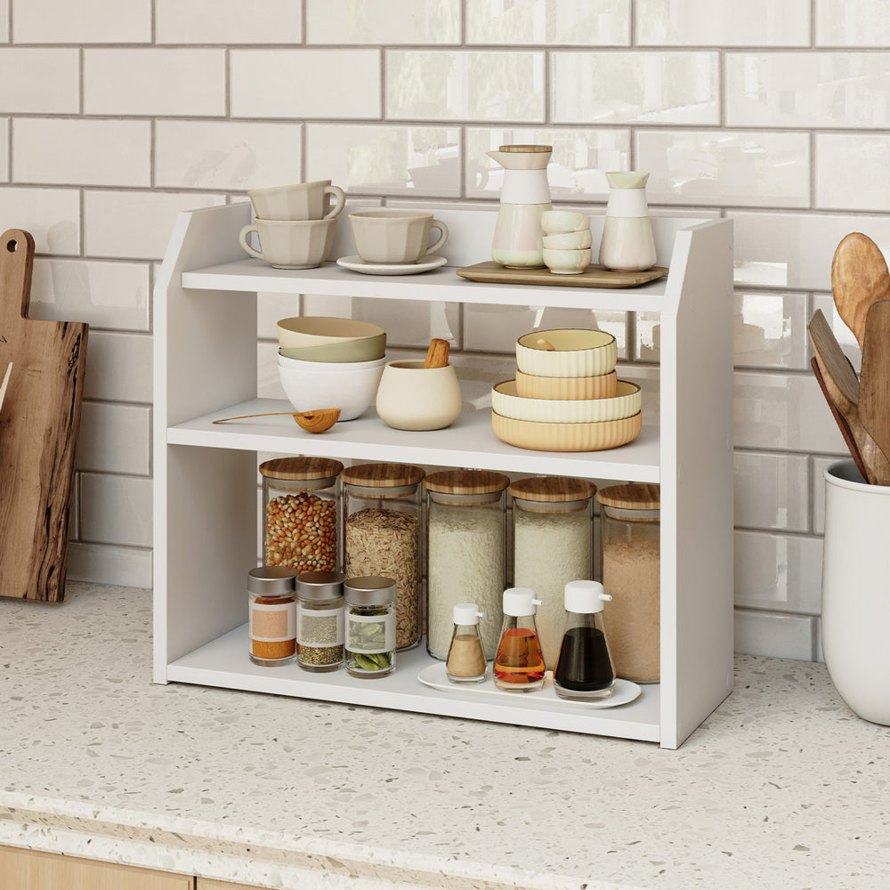 Three-tier white wooden countertop bookshelf with raised guardrails, ideal for organizing kitchen items and books.