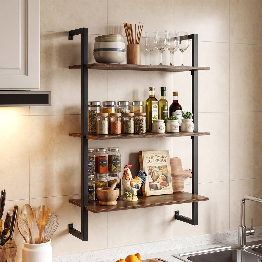 3-tier floating kitchen shelf in rustic brown, featuring glassware and spices, ideal for home office or living room use.