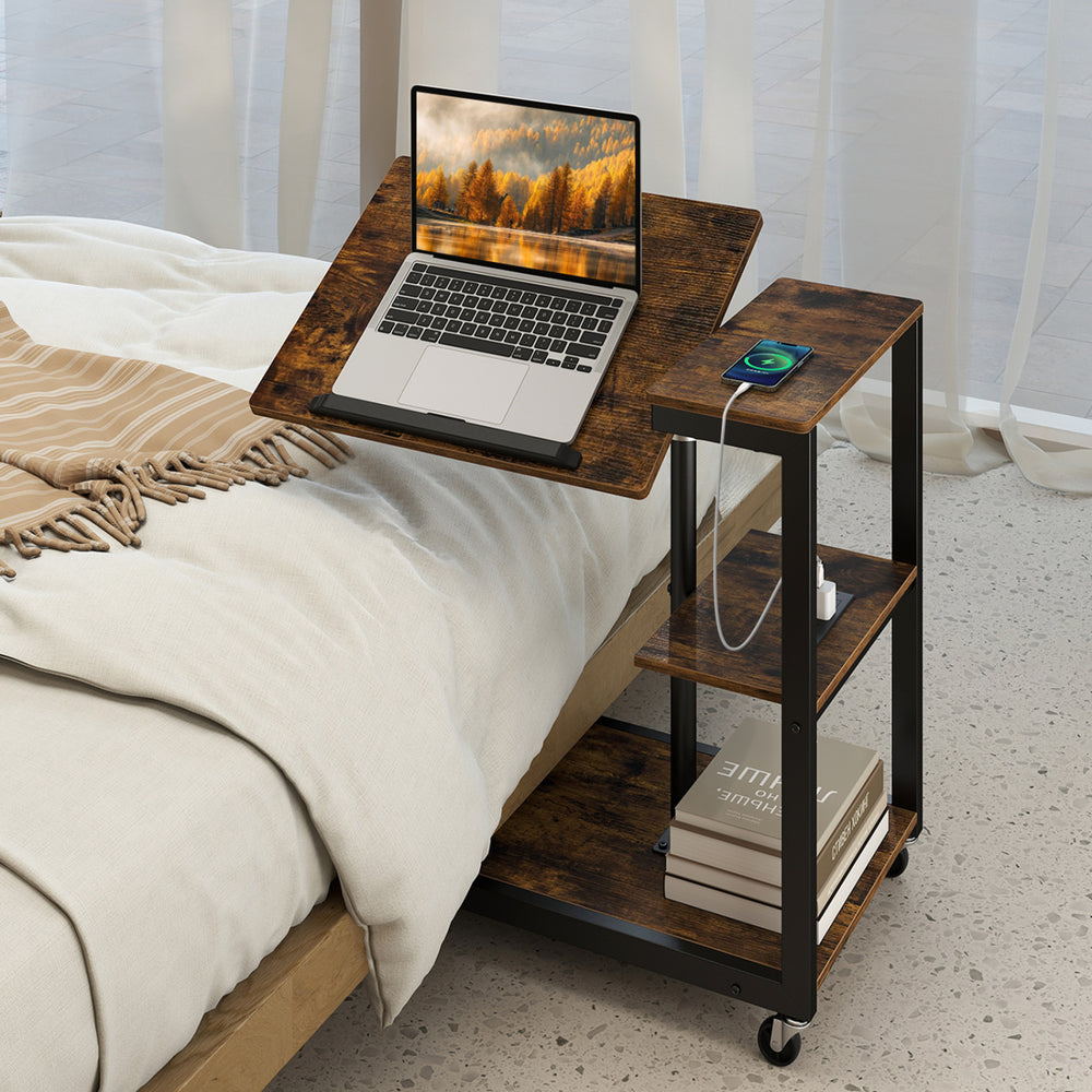 Mobile couch side table with tiltable tabletop, adjustable height, and USB ports for convenient charging and storage.