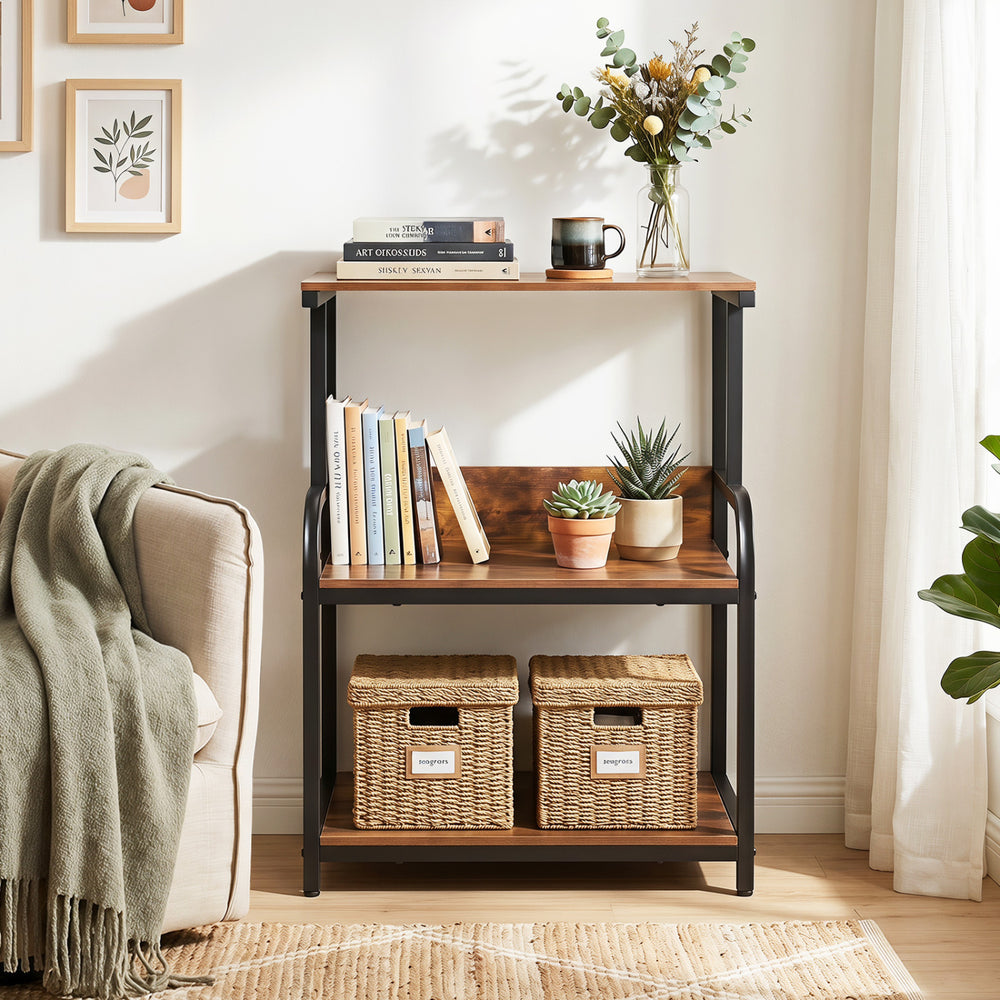 3-tier rustic brown printer stand with adjustable shelf, lockable wheels, and storage for books and plants in a living room.