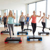 Group of women using the 3-in-1 aerobic step platform set for fitness training in a bright gym environment.