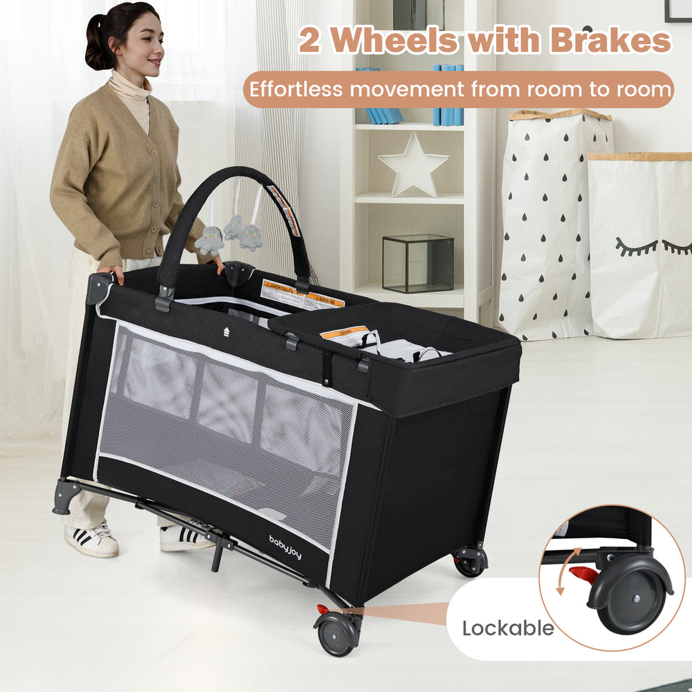 Portable baby crib with changing table in black, featuring lockable wheels for easy movement and breathable mesh walls.