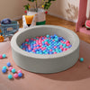 Round gray foam ball pit filled with vibrant ocean balls, designed for toddlers' indoor play and sensory stimulation.