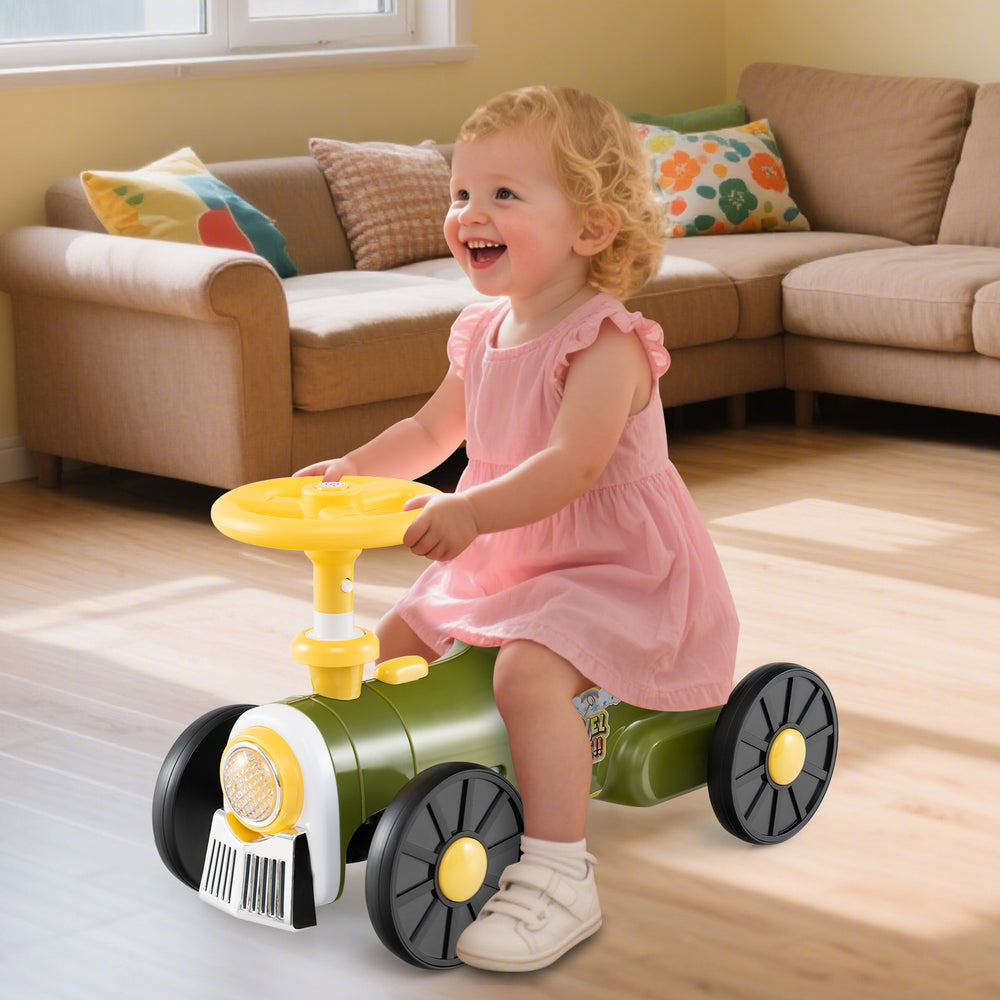 Child riding a green toy tractor with steering wheel and train whistle, featuring under-seat storage for toys.