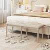 Upholstered bench with button-tufted seat and carved rubber wood legs, ideal for bedroom or living room seating.