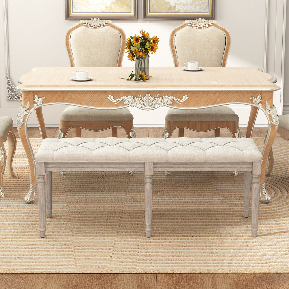 Upholstered bench with carved rubber wood legs, button-tufted seat, suitable for dining or living room use.