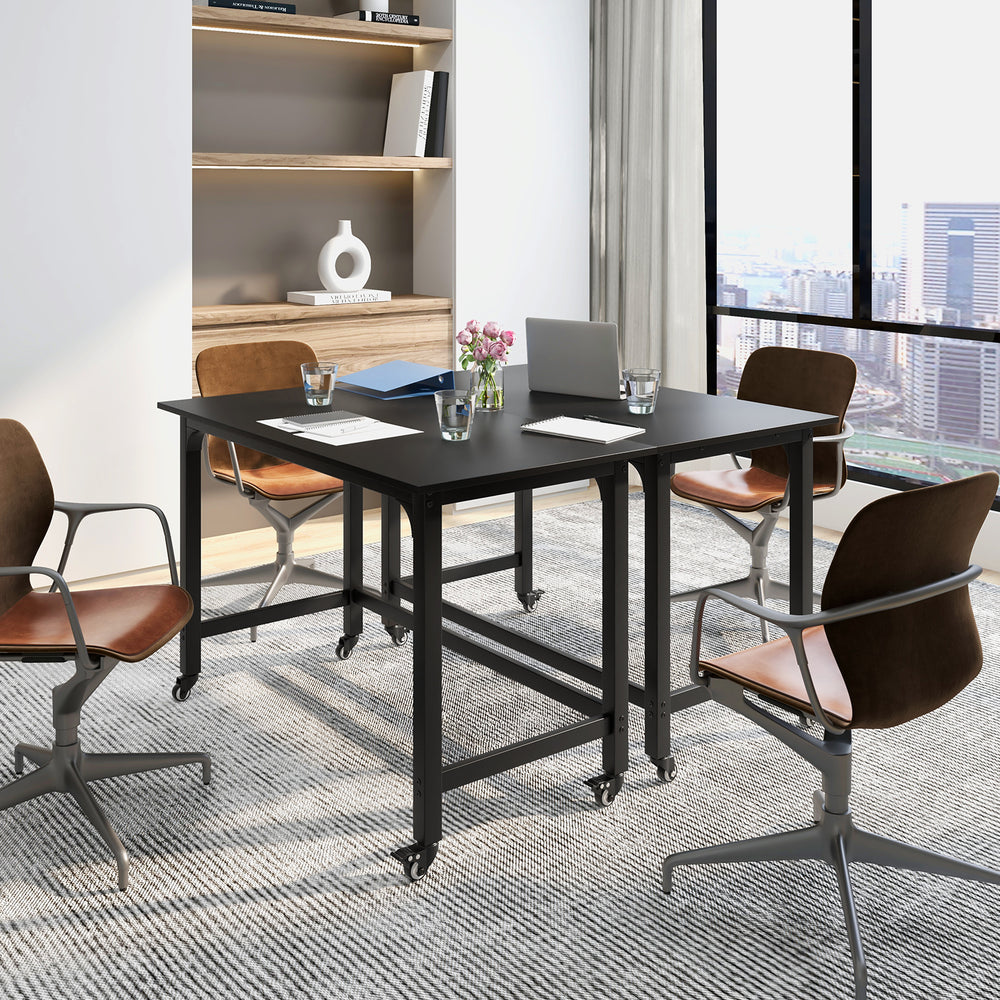 Mobile computer workstation with a 48" black tabletop and four smooth casters, ideal for versatile office setups.