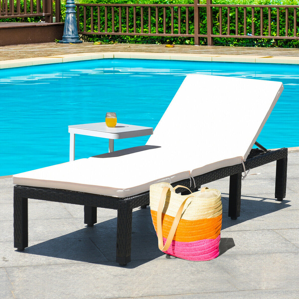 Cushioned white patio rattan lounge chair with adjustable backrest, perfect for poolside relaxation.