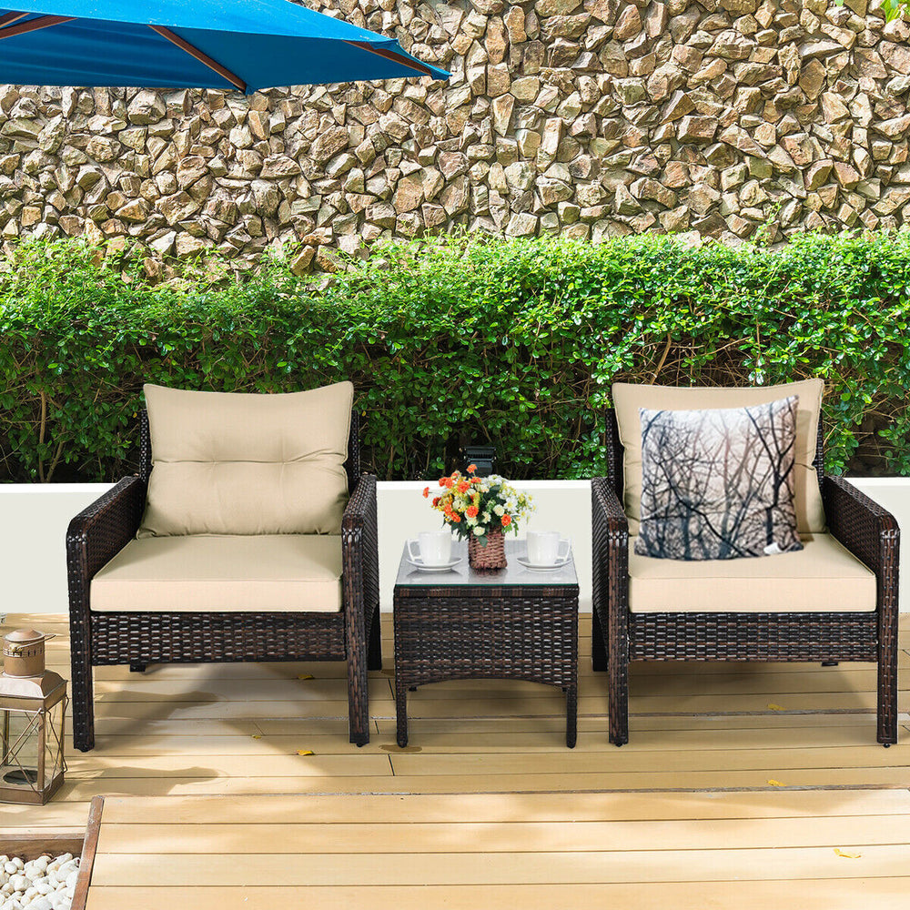 Two beige cushioned rattan chairs with a glass table, perfect for outdoor patio relaxation and stylish backyard decor.