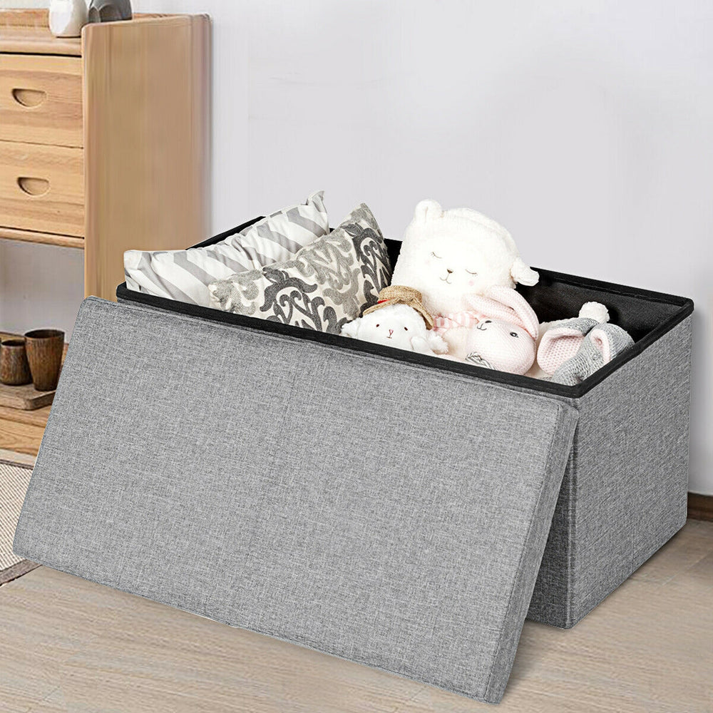 Light gray folding storage ottoman with lift top, spacious interior for blankets and toys, made of sturdy MDF.