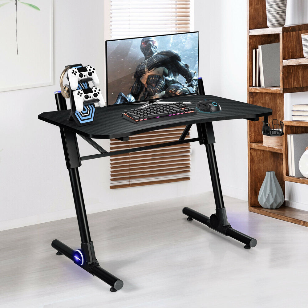 Height adjustable gaming desk with blue LED lights, spacious carbon fiber surface, and sturdy Z-shaped legs for.