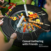 Outdoor fire pit with BBQ grill, featuring skewers and fresh ingredients, perfect for casual gatherings and backyard.