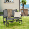 Gray iron patio rocking chair with a cozy blanket and pillow, perfect for outdoor relaxation in your backyard.