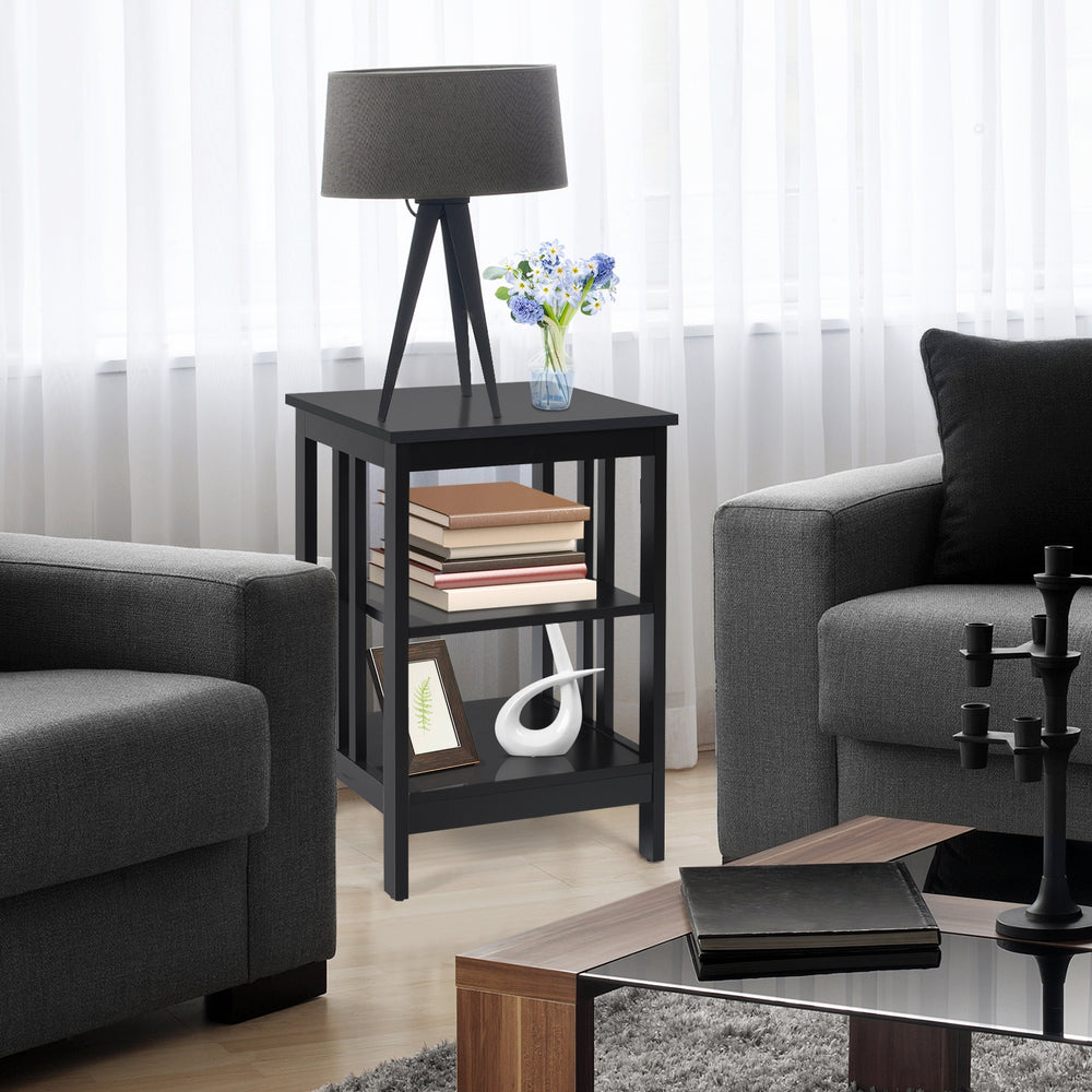 3-tier black nightstand with round corners, featuring open compartments for storage in a stylish living room setting.