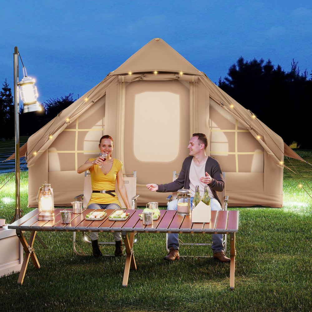 Inflatable camping tent for 4-6 people with mesh windows, set up outdoors for a cozy evening gathering.