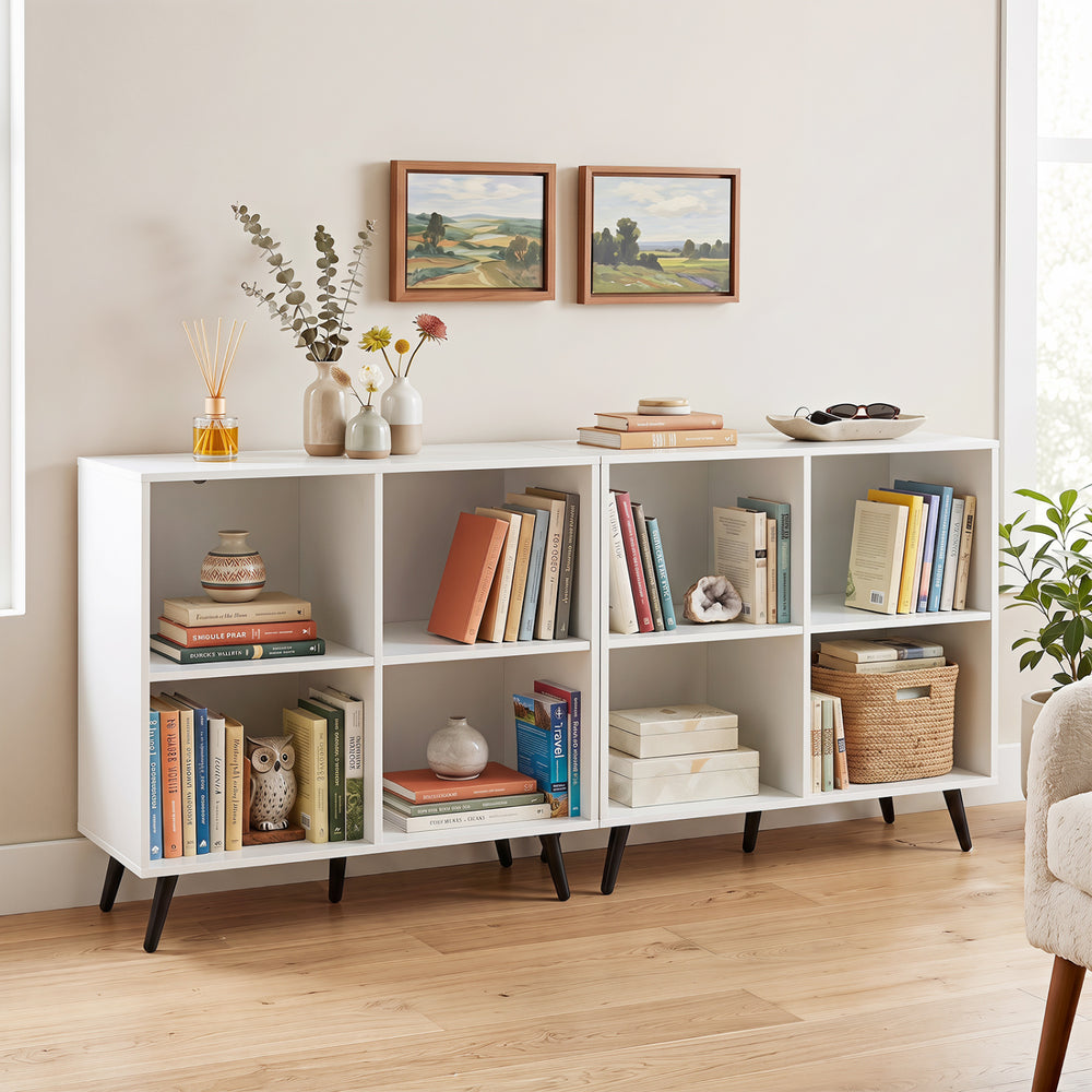White 4-cube wooden bookshelf with 5 metal legs, perfect for organizing books and displaying decor in any room.