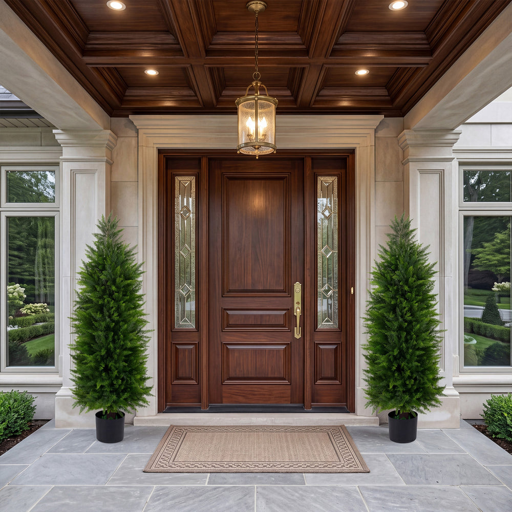 Two 4 FT artificial topiary cedar cypress trees in cement-filled pots, enhancing a grand entrance with greenery.