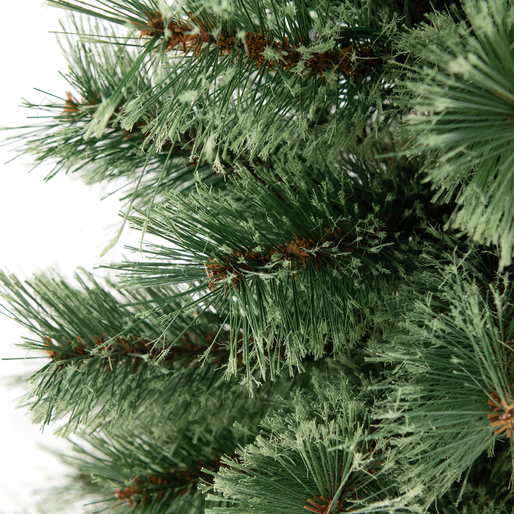 Close-up of lush flowering pine needles on a 4 feet pre-lit Christmas tree with warm LED lights for festive decor.