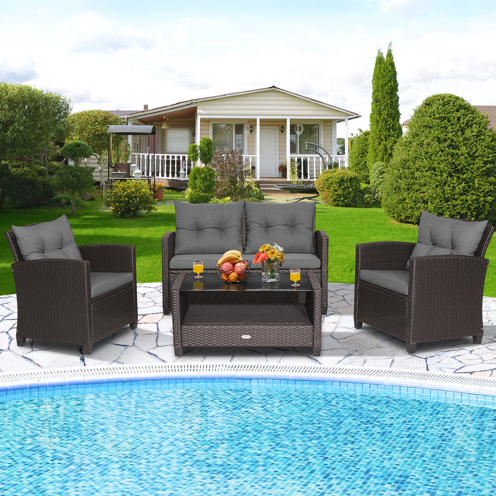 Patio rattan conversation set with gray cushions, featuring a coffee table, loveseat, and two single sofas by the.