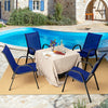 Four navy stackable patio dining chairs with armrests arranged around a table by a pool, perfect for outdoor dining.