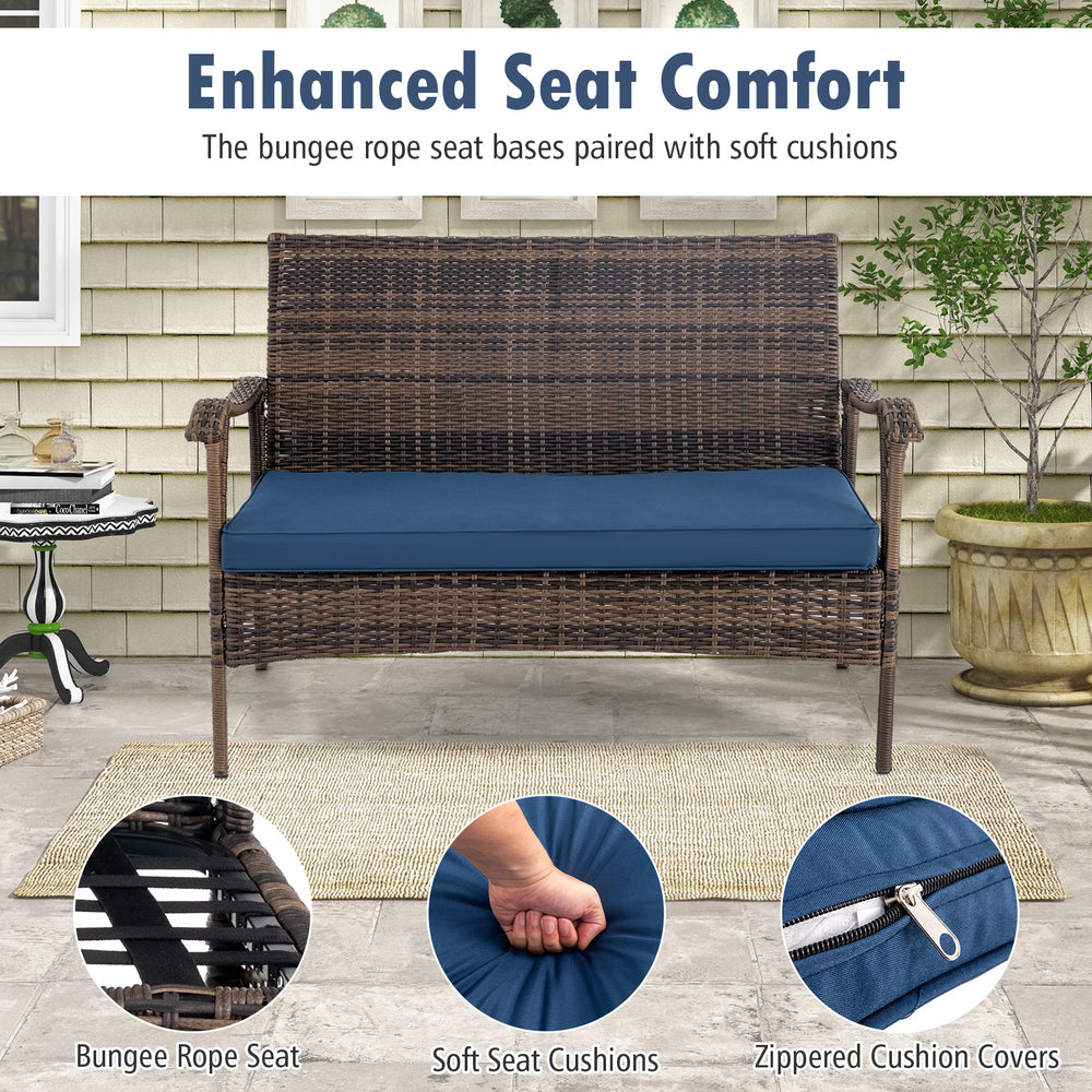 Navy blue soft cushions on a wicker rocking loveseat with bungee rope seat, perfect for outdoor relaxation.