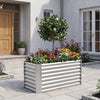 Galvanized metal raised garden bed with vibrant flowers and a tree, perfect for backyard or patio gardening.