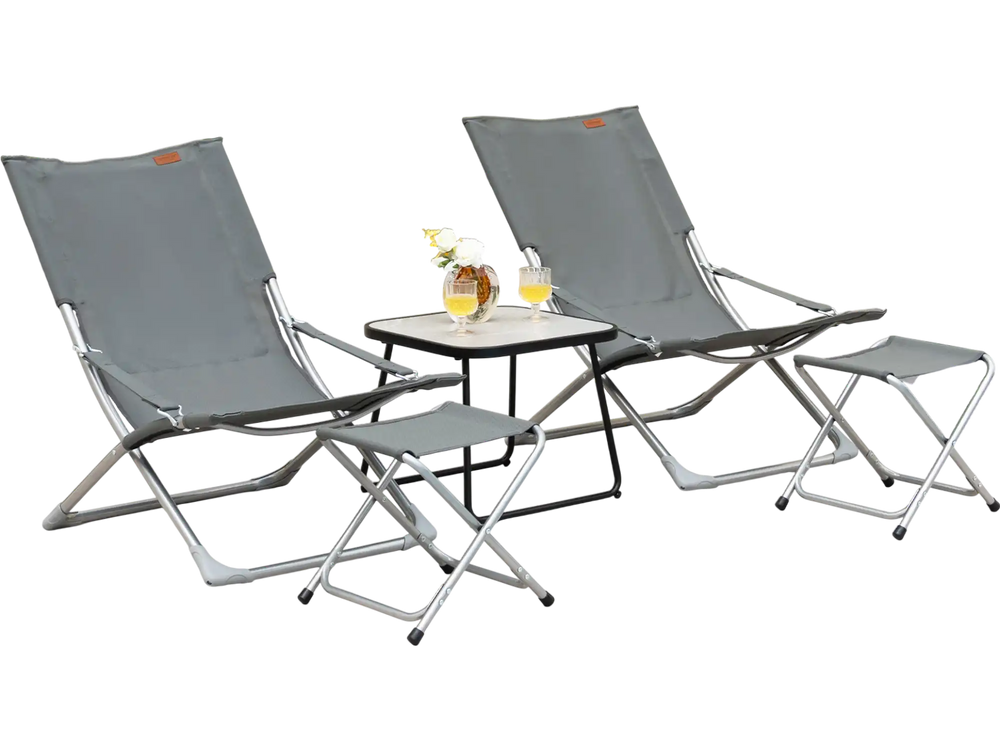 Two gray folding lounge chairs with footrests and a coffee table, perfect for patio or poolside relaxation.