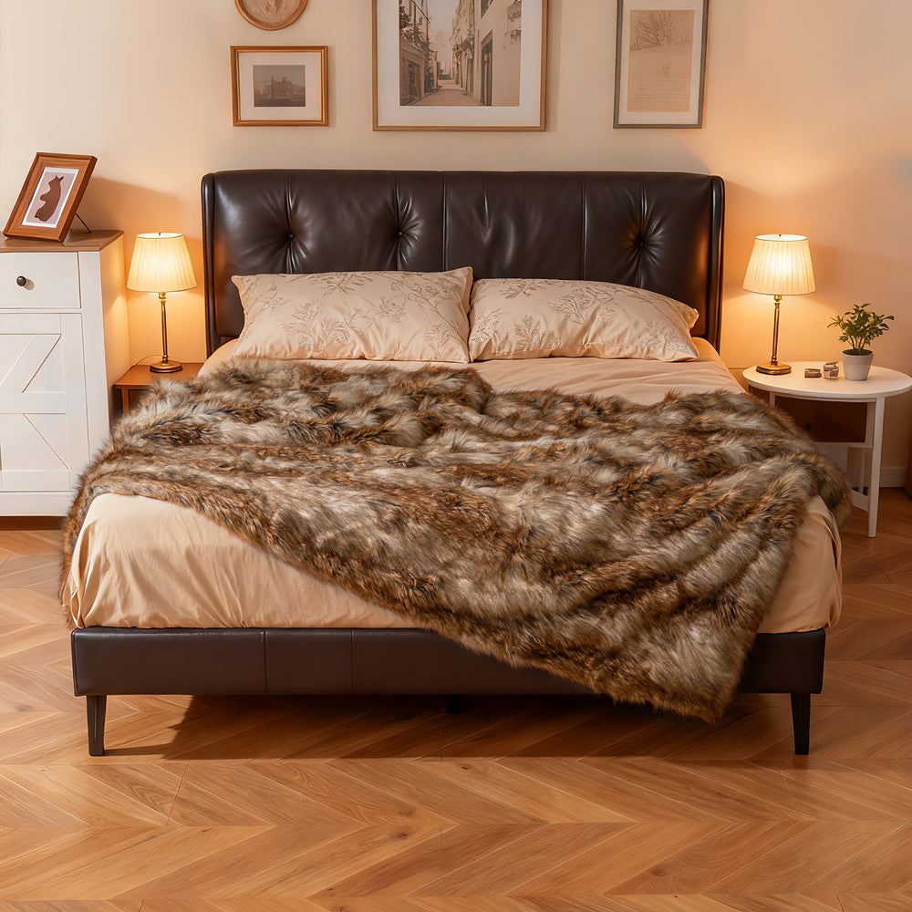 Luxurious 540GSM faux raccoon fur blanket draped over a bed, featuring a soft texture and double-sided design.