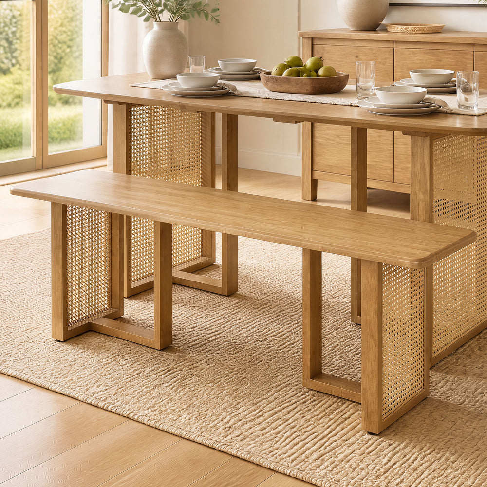 Solid rubber wood dining bench with rattan legs, featuring a natural finish and T-shaped structure for stability.