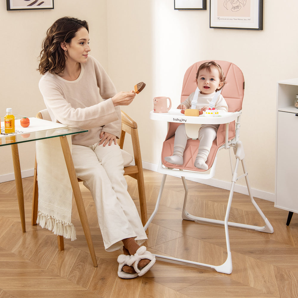 Compact pink highchair with adjustable tray and footrest, featuring a removable cushion for easy cleaning and storage.