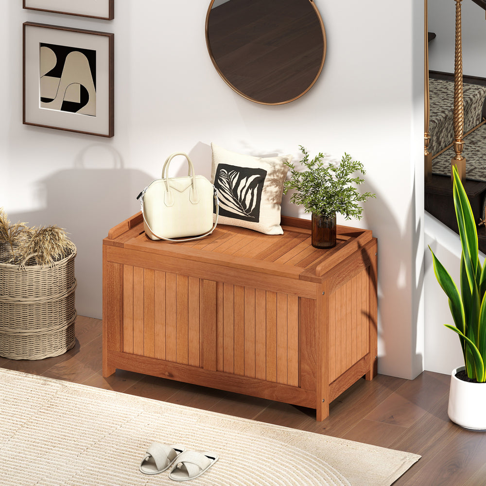 Wooden 52-gallon patio deck box with flip top, ideal for cushions and outdoor storage, placed in a stylish indoor.