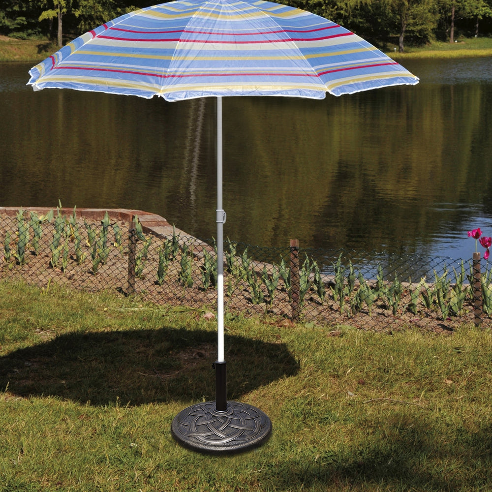 Heavy duty 22-inch round umbrella base stand with decorative bronze finish, securely holding an umbrella by the lake.