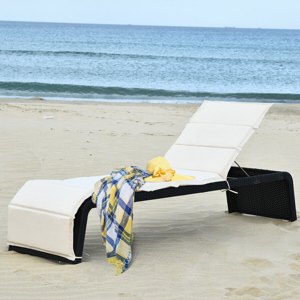 Patio rattan lounge chair with adjustable back, cushioned in white, perfect for poolside or beach relaxation.