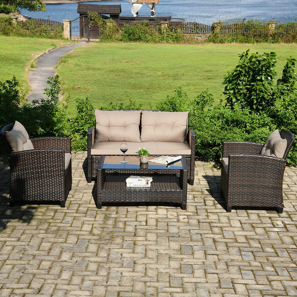 4-piece outdoor rattan furniture set featuring a loveseat, two single sofas, and a glass table, ideal for backyard.