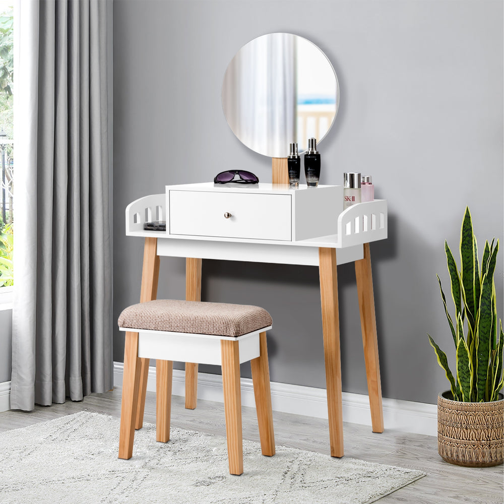 Wooden makeup dressing table set with drawer, round mirror, and cushioned stool, perfect for organizing beauty items.