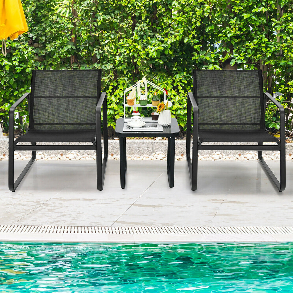 Two ergonomic black patio chairs with a glass top table, perfect for outdoor relaxation by the poolside.