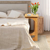 Bamboo bedside table with storage bag, featuring round corners, ideal for saving space beside a bed or sofa.